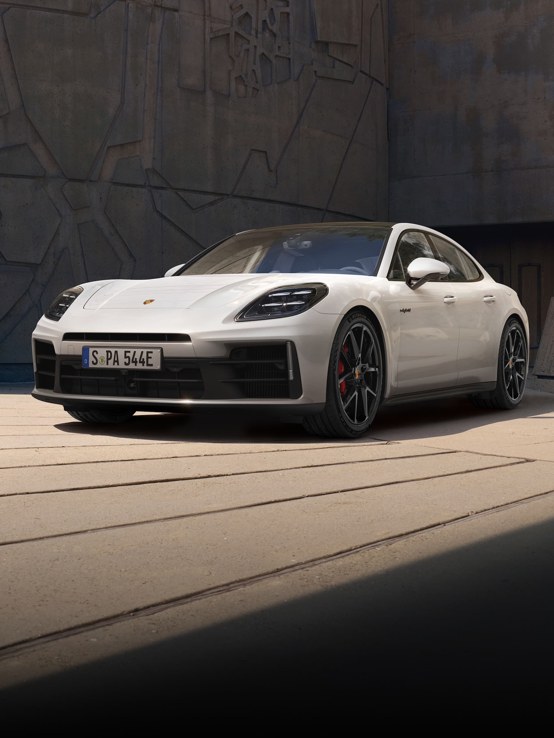 Un Porsche Panamera estacionado frente a un edificio moderno.